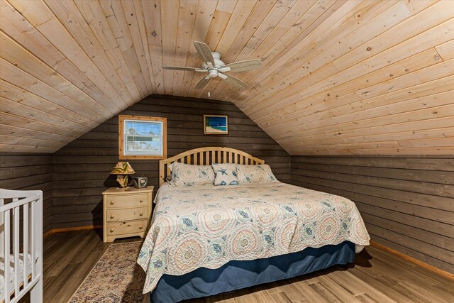 bedroom with wood walls, wood ceiling, wood-type flooring, vaulted ceiling, and ceiling fan