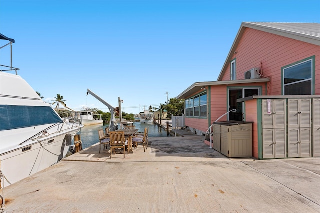 view of patio featuring a water view and a dock