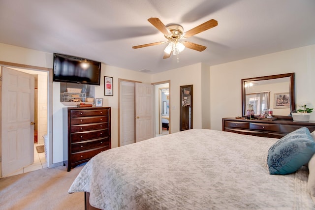 carpeted bedroom with ceiling fan and ensuite bath