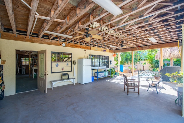 garage with white fridge and ceiling fan