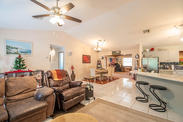 tiled living room with lofted ceiling and ceiling fan with notable chandelier