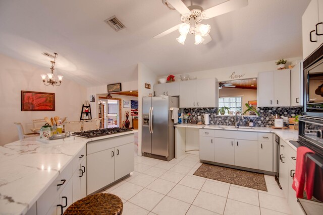 kitchen featuring tasteful backsplash, appliances with stainless steel finishes, vaulted ceiling, and white cabinets