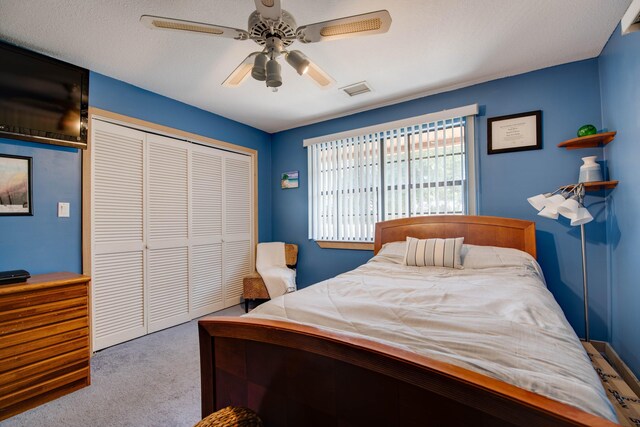 carpeted bedroom featuring ceiling fan and a closet