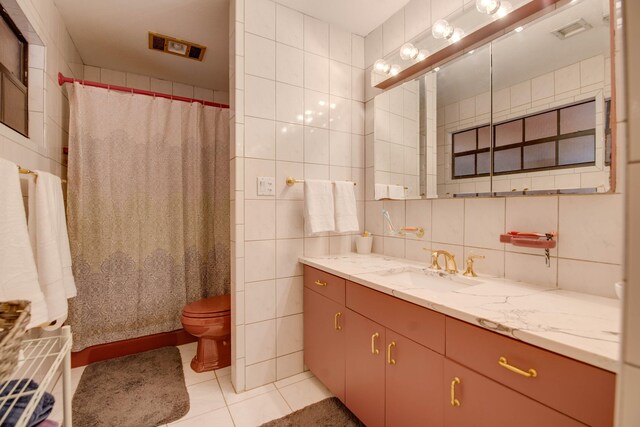 bathroom featuring tile walls, backsplash, tile patterned flooring, vanity, and toilet