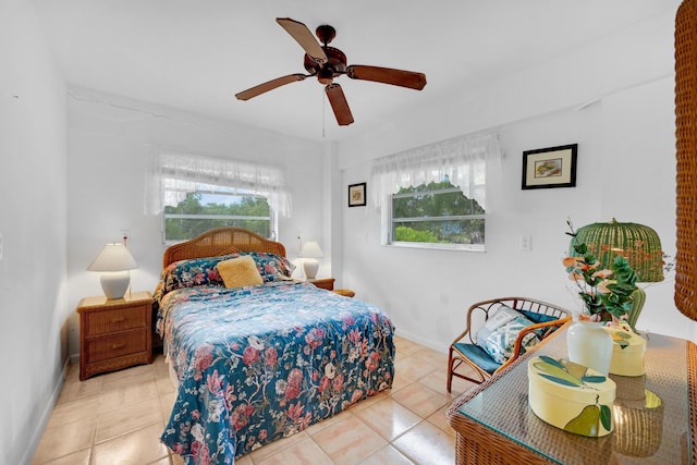 bedroom featuring ceiling fan, multiple windows, and light tile patterned floors