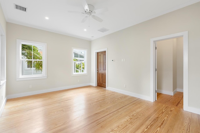 unfurnished room featuring light wood-type flooring, visible vents, and baseboards