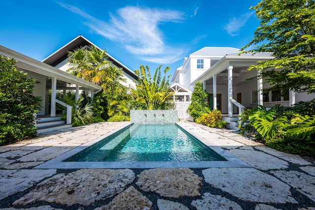 outdoor pool with a patio and fence