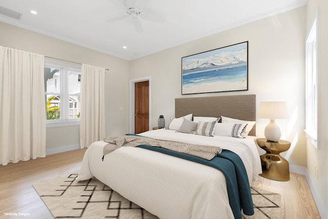 bedroom featuring visible vents, crown molding, baseboards, and wood finished floors