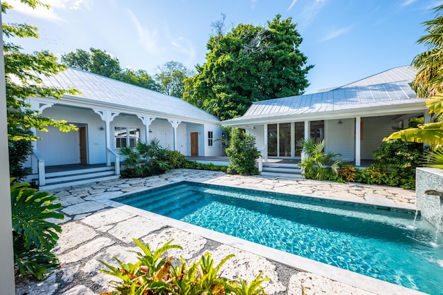 outdoor pool with covered porch and a patio