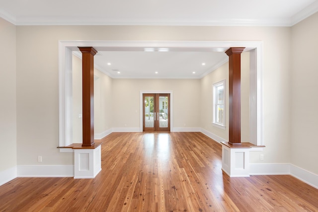 spare room with light wood-type flooring, french doors, decorative columns, and baseboards