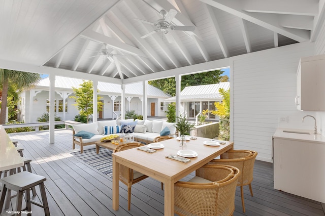 sunroom / solarium with vaulted ceiling with beams, a wealth of natural light, a ceiling fan, and a sink