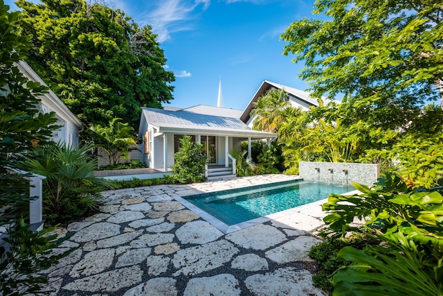 outdoor pool featuring a patio and fence