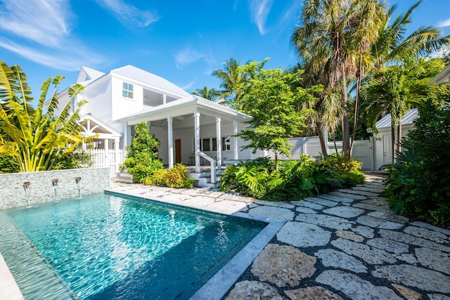 back of house featuring fence, a gate, and a fenced in pool