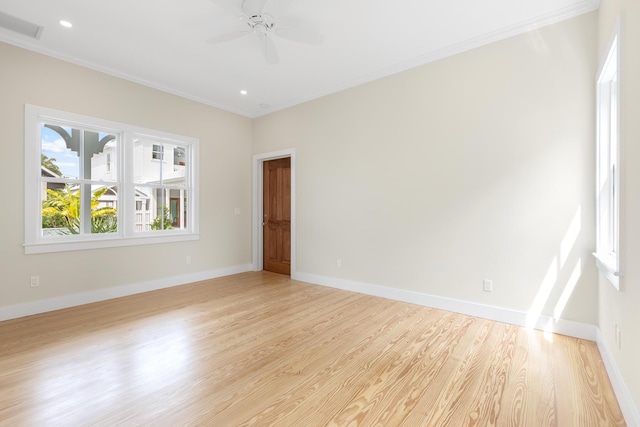 unfurnished room featuring light wood-style flooring, a ceiling fan, visible vents, baseboards, and crown molding