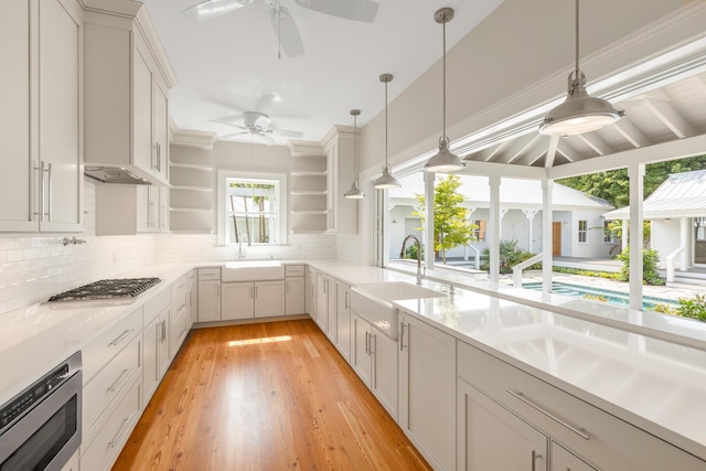 kitchen with decorative backsplash, appliances with stainless steel finishes, open shelves, and a sink