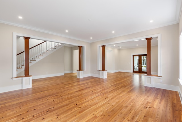 spare room featuring decorative columns, baseboards, crown molding, light wood-type flooring, and recessed lighting