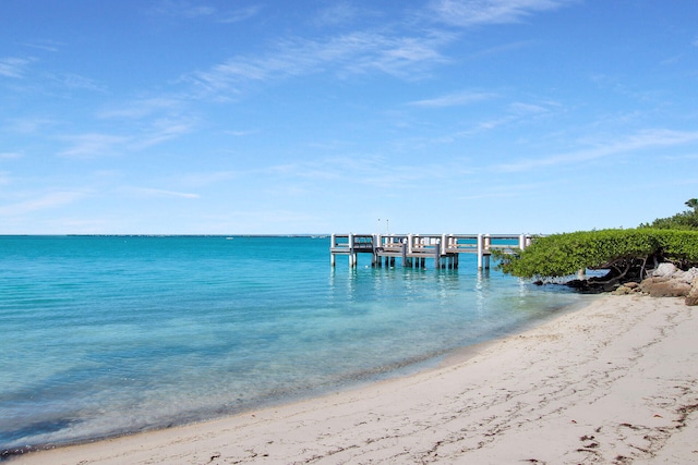 view of dock featuring a water view and a view of the beach