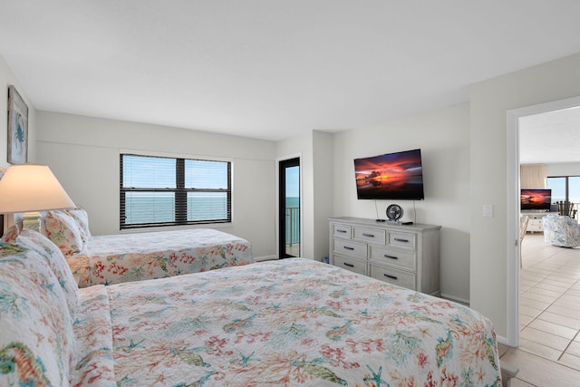 bedroom featuring light tile patterned floors, multiple windows, and baseboards