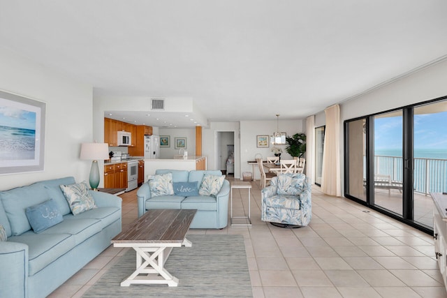 living area featuring a water view, light tile patterned floors, and visible vents