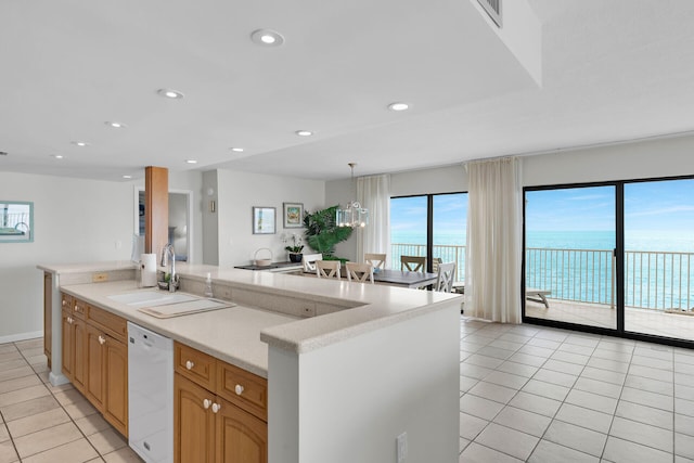 kitchen featuring a water view, dishwasher, a large island, and a sink