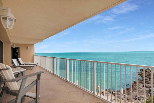 balcony featuring a water view and a view of the beach