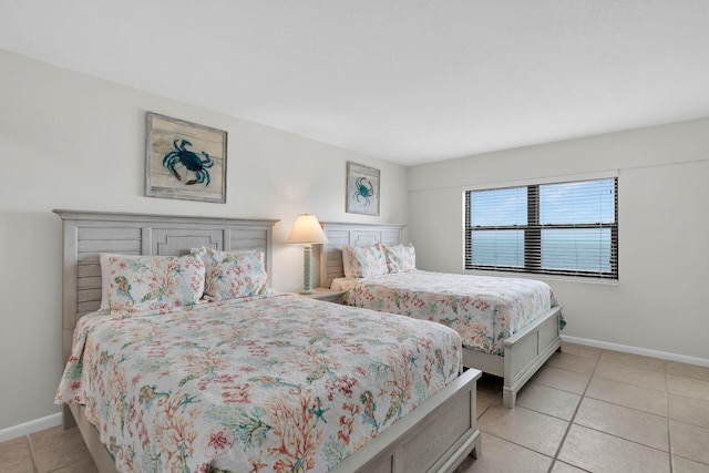 bedroom with light tile patterned floors and baseboards