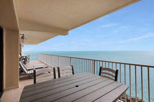 balcony featuring a water view and outdoor dining area