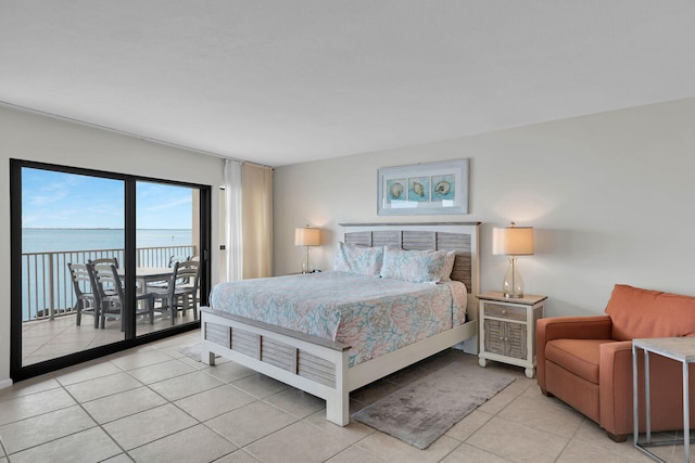 bedroom featuring a water view, access to exterior, and light tile patterned floors