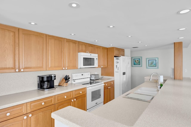 kitchen featuring recessed lighting, white appliances, light countertops, and a sink