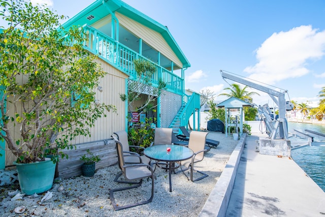 view of patio / terrace with a water view, boat lift, stairway, and a boat dock