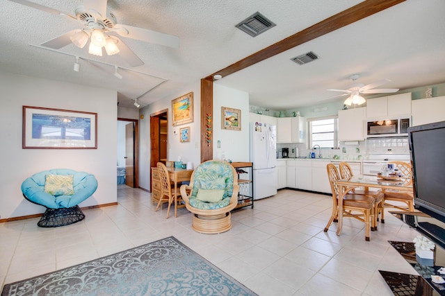 interior space featuring freestanding refrigerator, white cabinets, stainless steel microwave, and visible vents