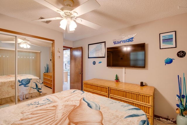 bedroom featuring a ceiling fan, a closet, and a textured ceiling