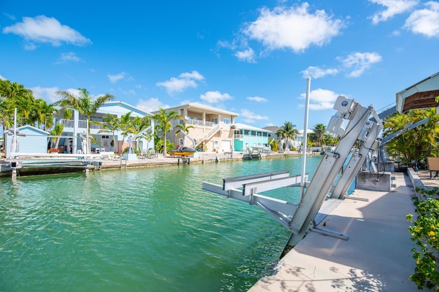 dock area featuring a water view, boat lift, and a residential view