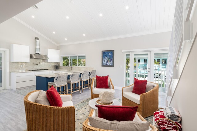 living area featuring french doors, recessed lighting, crown molding, and light wood-type flooring