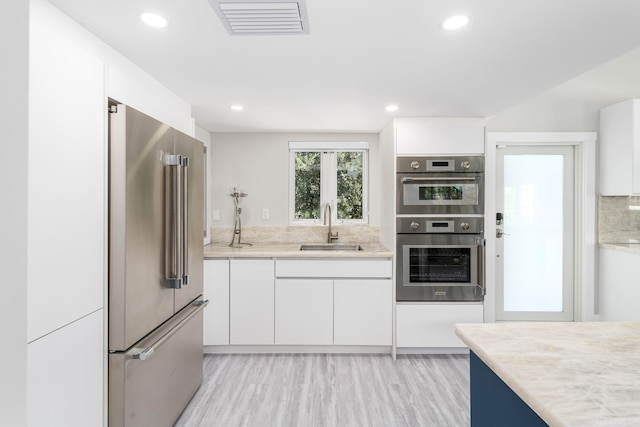 kitchen featuring a sink, light countertops, white cabinets, and stainless steel appliances