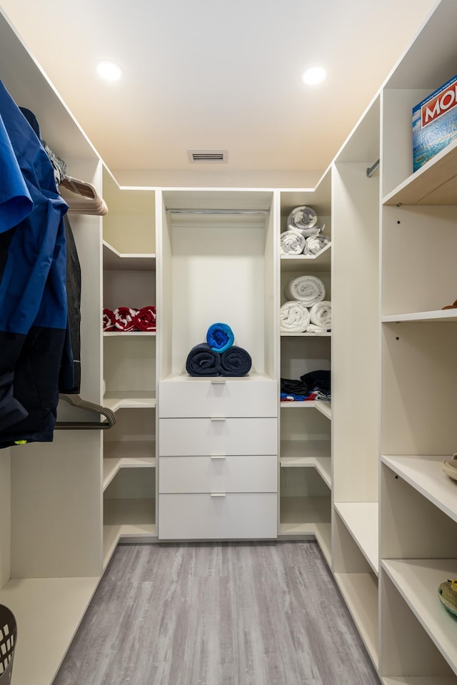 spacious closet featuring wood finished floors and visible vents