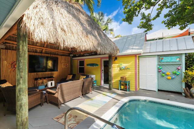 back of house featuring a pool side deck and outdoor lounge area