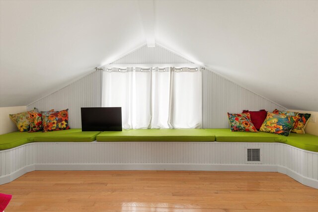 additional living space with vaulted ceiling and light hardwood / wood-style floors