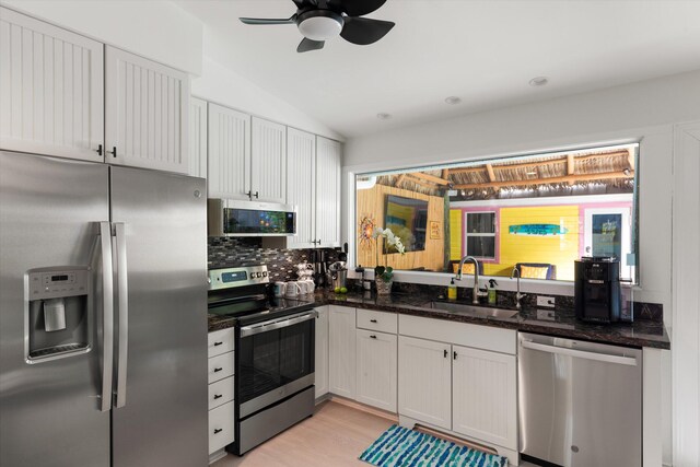 kitchen featuring white cabinetry, appliances with stainless steel finishes, sink, and dark stone countertops