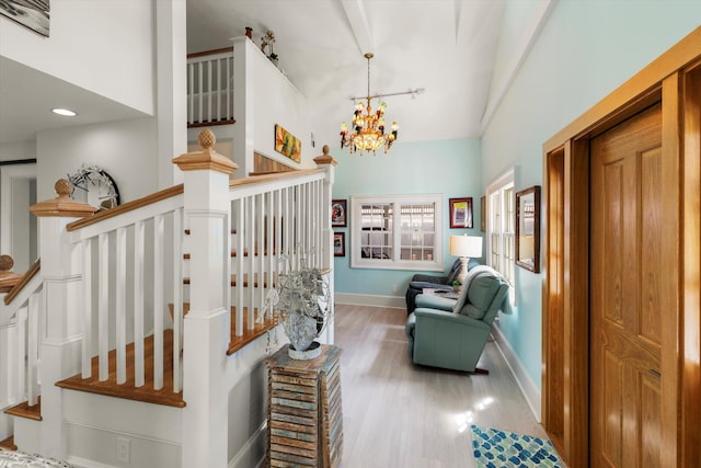 stairway with vaulted ceiling, hardwood / wood-style floors, and an inviting chandelier