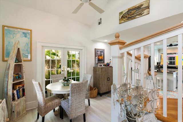 dining space with light hardwood / wood-style flooring, high vaulted ceiling, french doors, and ceiling fan