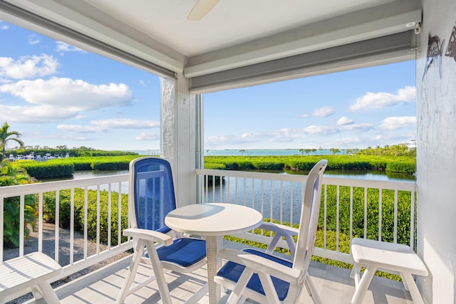 balcony with a water view and ceiling fan