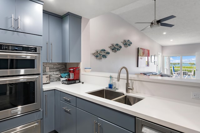 kitchen with sink, dishwasher, double oven, ceiling fan, and decorative backsplash