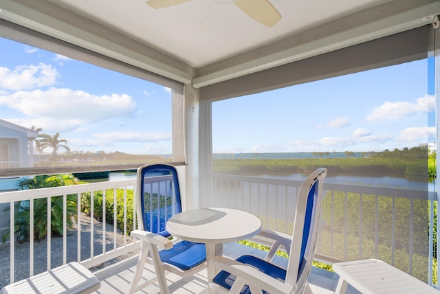 balcony featuring a water view and ceiling fan