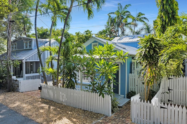 820 Carsten Ln, Key West, FL 33040 - view of side of home featuring a metal roof, a gate, and a sunroom