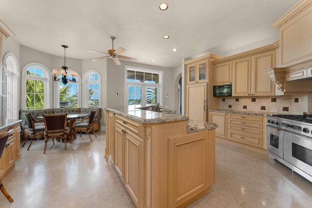 69 Cannon Royal Dr, Shark Key, FL 33040 - kitchen featuring double oven range, recessed lighting, black microwave, cream cabinets, and tasteful backsplash