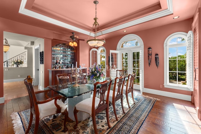 69 Cannon Royal Dr, Shark Key, FL 33040 - dining room with a tray ceiling, wood-type flooring, and baseboards