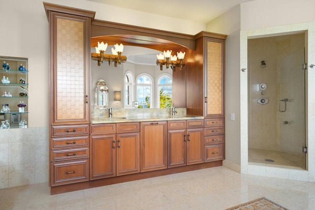 69 Cannon Royal Dr, Shark Key, FL 33040 - bathroom featuring double vanity, a stall shower, an inviting chandelier, and a sink