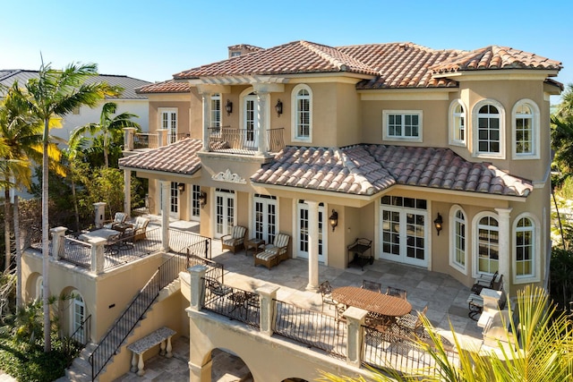 69 Cannon Royal Dr, Shark Key, FL 33040 - back of house featuring a tiled roof, stucco siding, french doors, a chimney, and a patio