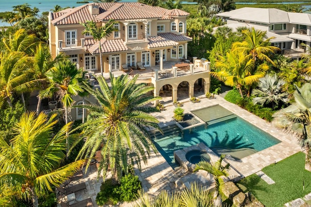 69 Cannon Royal Dr, Shark Key, FL 33040 - rear view of house with a patio, a balcony, a pool with connected hot tub, french doors, and a tiled roof